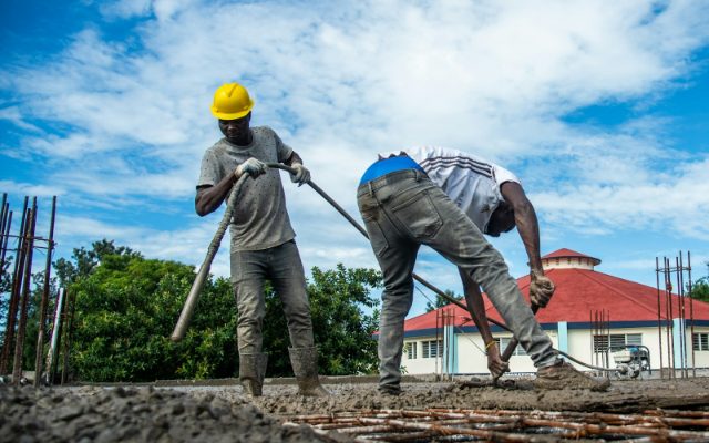Concrete crew pouring and leveling a reinforced slab