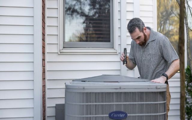 HVAC technician servicing an outdoor air conditioning unit