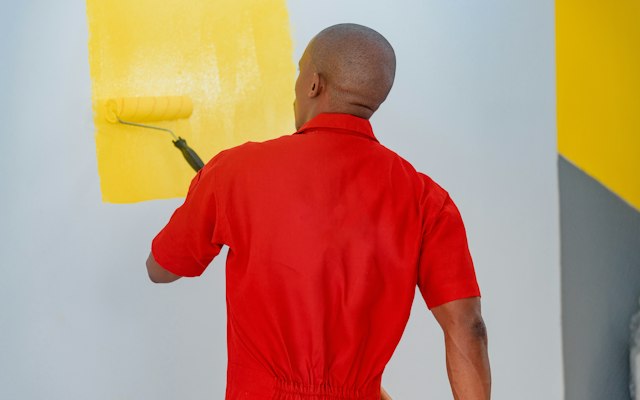 Professional painter rolling fresh paint onto an interior wall